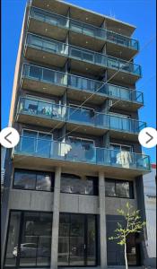 Un edificio de apartamentos alto con balcón y dos círculos. en Home Rosario, en Rosario