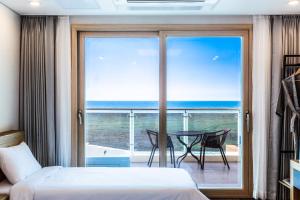 a bedroom with a bed and a view of the ocean at Sea Stay Hotel in Jeju