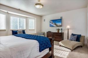 a bedroom with a large bed and a chair at Riviera Retreat in Salt Lake with Private Hot Tub and Theater in Millcreek