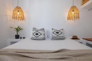a bedroom with a bed with two pillows on it at Del Sol View Arnados Tinos in Arnados
