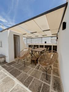 een patio met 2 stoelen en een tafel op een dak bij Lilibeth Luxury Suites - Ostuni in Ostuni