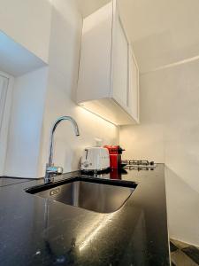 een keuken met een wastafel en witte kasten bij Lilibeth Luxury Suites - Ostuni in Ostuni