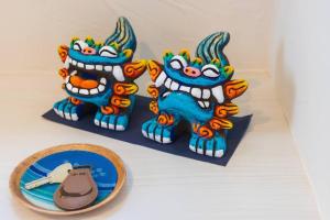 石垣岛石垣島一棟貸し 潮的一组三个小雕像坐在盘子旁边