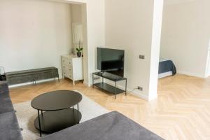 a living room with a table and a television at Stylish apartment in the heart of Tallinn, free parking in Tallinn