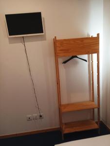 a flat screen tv hanging on a wall next to a shelf at Al-Xelb guesthouse in Silves +15 photos