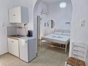 a small white room with a bed and a table at Katerina Yalos in Ios Chora