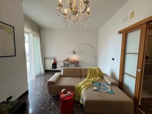 Una sala de estar con un sofá y una lámpara de araña. en Casa Gagge by Holiday World, en Génova