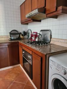 une cuisine avec une cuisinière et une machine à laver dans l'établissement Jawhara smir red chaussé vue jardin, à M'diq