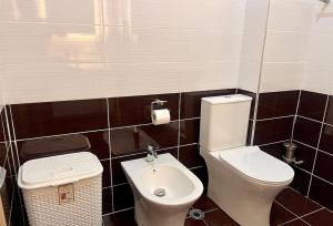a bathroom with a toilet and a sink at Viluni Coast Apartment in Velipojë +11 photos