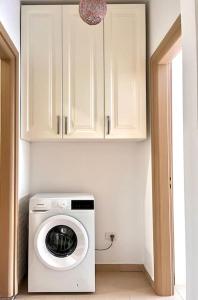 a kitchen with a washing machine in a room at Viluni Coast Apartment in Velipojë