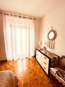 a bedroom with a bed and a dresser and a mirror at La casa di Bianca - Casa Vacanze in Villa Opicina