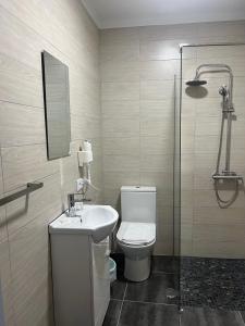 a bathroom with a toilet and a sink and a shower at White Guest in Fátima