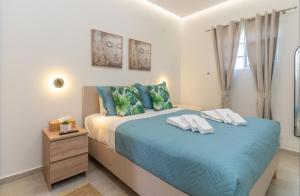 a bedroom with a bed with blue sheets and pillows at St John Residence in Chania +13 photos