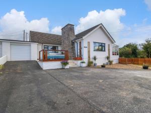 a white house with a driveway at Greenfield in Holyhead