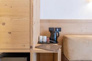 a table with a coffee maker and a coffee pot on it at Hotel Meida in Pozza di Fassa