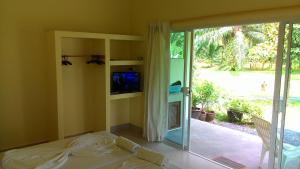 a bedroom with a bed and a sliding glass door at Aathid Garden Khao Lak in Khao Lak