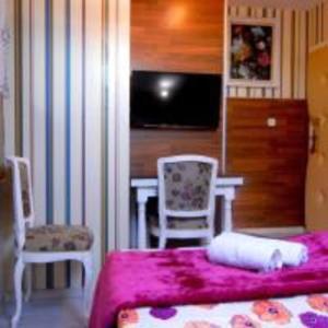 a bedroom with a bed and a table and a chair at Villa Lucia - Apartments&Rooms in Slavonski Brod