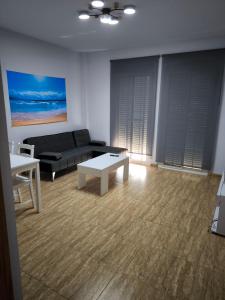 a living room with a couch and a table at BALERMAPLAYA calle lago in Belerma