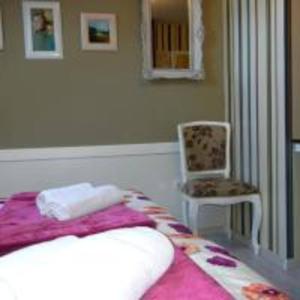 a bedroom with a bed and a chair and a chair at Villa Lucia - Apartments&Rooms in Slavonski Brod
