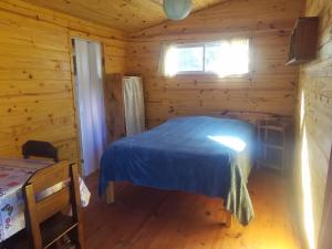 a bedroom with a bed in a log cabin at Chalets rustiques en pleine nature, L'ARCHIPEL in Punta Del Diablo
