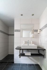 bagno bianco con lavandino e specchio di Domaine de Ramonjuan a Lesponne