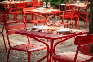 a red table with chairs and wine glasses on it at La Casina in Casteggio +23 photos