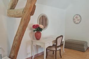 a table with a vase of flowers and two chairs at Belle maison, 2 chambres dans corps de ferme - logement Raphaël in Villiers-sous-Grez +41 photos
