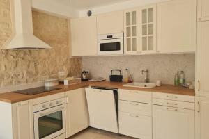 a white kitchen with white cabinets and a sink at Belle maison, 2 chambres dans corps de ferme - logement Raphaël in Villiers-sous-Grez