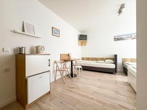 a kitchen and living room with white walls and wooden floors at Chatka Morska in Karwia