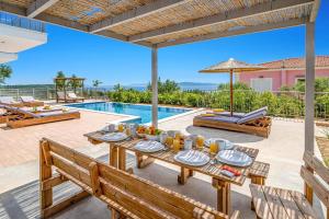 a villa with a swimming pool and a dining table at Villa Ble by Villa Plus in Plateies