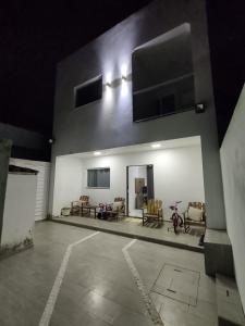 a white building with chairs and tables on it at Suíte confortável para o FIG! Inclui cozinha e sala in Garanhuns