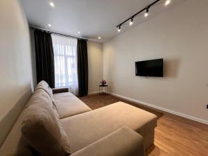 a living room with a couch and a flat screen tv at Апартаменты ЖК АТАМЕКЕН in Karagandy