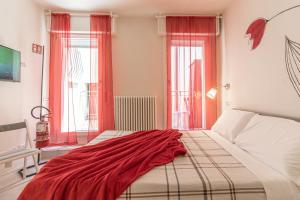 a bedroom with a bed with a red blanket on it at Suite Modena al Centro - Affitti Brevi Italia in Modena