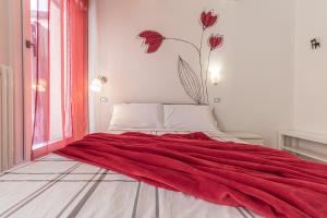a red blanket laying on a bed in a room at Suite Modena al Centro - Affitti Brevi Italia in Modena