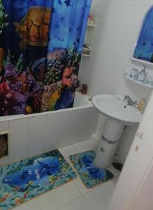 a bathroom with a sink and a shower curtain at Joli appartement vue sur la mer in Sousse