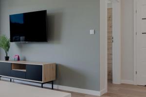 ein Wohnzimmer mit einem TV an der Wand in der Unterkunft VacationClub Marina Rogowo Apartament 56 in Rogowo