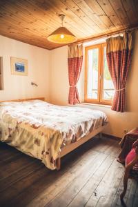 Un dormitorio con una cama en una habitación con ventana. en Les MARMOTTES, en Saint-Chaffrey