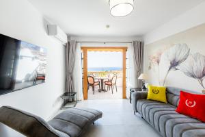 a living room with a couch and a television at Los Geranios 307 in Adeje