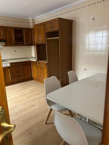 a kitchen with a white table and chairs at Pensión Arnedo in Arnedo +19 photos