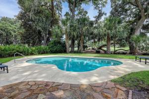 una piscina en un patio con árboles en Luxury 4 BR 45 BA Home w Double Master Suites private pool Sea Pines Resort Gorgeous views, en Hilton Head Island