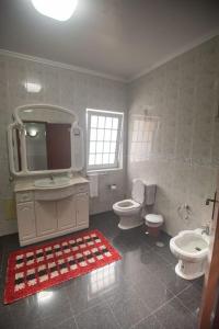 a bathroom with two toilets and a sink and a mirror at Casa Gabriel Barbosa in Lagoa +36 photos