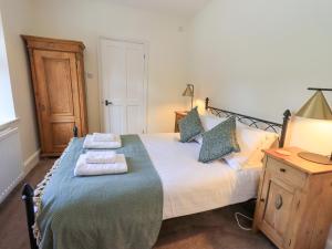 a bedroom with a bed with towels on it at Rowan Cottage in Grasmere