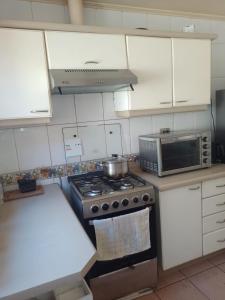 a kitchen with a stove and a microwave at Hospedaje Casa Mirador in Puerto Montt