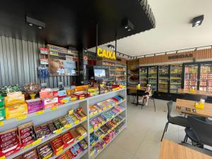 a woman sitting at a counter in a supermarket at Pousada Anadia in Cajá