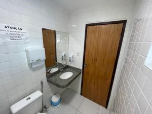a bathroom with a sink and a wooden door at Pousada Anadia in Cajá +27 photos