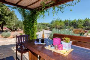 a wooden table with a bottle of wine on it at Spacious House with Private Pool in Stari Grad in Stari Grad