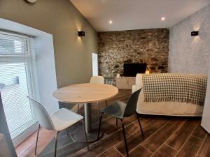 a dining room with a table and chairs and a couch at Castle Mill Cottages in Wexford