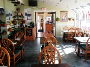 a dining room with wooden tables and chairs at Alpine Lodge Motel & Restaurant in Grande Cache