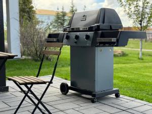 a grill and a chair on a patio at New&Stylish&Cozy Suit near Spruce Meadows Sleeps 6- Backyard-EV in Calgary