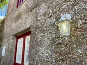 a light on the side of a stone building at Casa dos Cabencos in Terras de Bouro